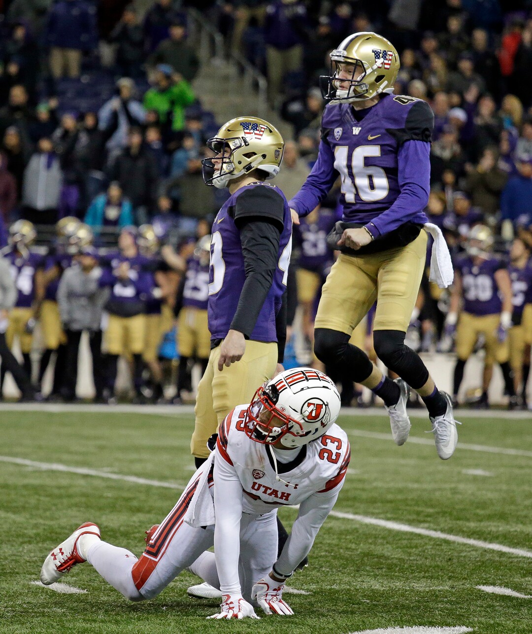 Utah's Julian Blackmon (23) looks on as Washington holder Race Porter (46) leaps as he reacts to the field goal of Tristan Vizcaino, center, to win the game as time ran out in the second half of an NCAA college football game Saturday, Nov. 18, 2017, in Seattle. Washington won 33-30. (AP Photo/Elaine Thompson)