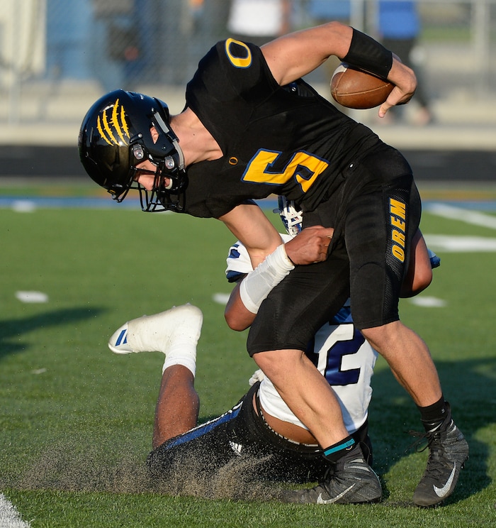 (Francisco Kjolseth  |  The Salt Lake Tribune)  Orem's quarterback Cooper Legas is taken down by Bingham's Sione Fotu in the first half of the game Thursday, Aug. 16, 2018 in Orem.