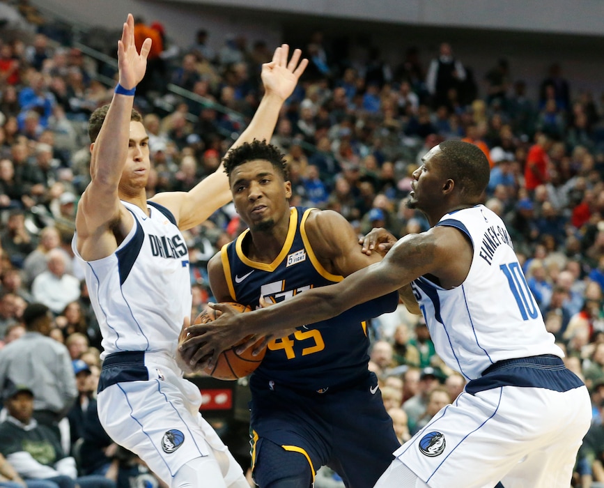 Dallas Mavericks forward Dwight Powell (7) and forward Dorian Finney-Smith (10) defend Utah Jazz guard Donovan Mitchell (45) during the second half of an NBA basketball game in Dallas, Wednesday, Nov. 14, 2018. Dallas won 118-68. (AP Photo/Michael Ainsworth)