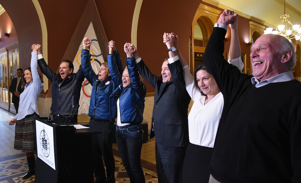 (Francisco Kjolseth | The Salt Lake Tribune) Salt Lake City officials celebrate after getting the news that U.S. Olympics Committee chose their city over Denver to bid for a future Winter Olympics, possibly 2030, as they gather at City Hall on Friday, Dec. 14, 2018, to announce the decision. Raising their arms in celebration are council chairwoman Erin Mendenhall, former Salt Lake Organizing Committee chief operating officer Fraser Bullock, Utah Sports Commission CEO Jeff Robbins, Mayor Jackie Biskupski, Gov. Gary Herbert, speed skater Catherine Raney Norman and councilman Jim Bradley, from left.