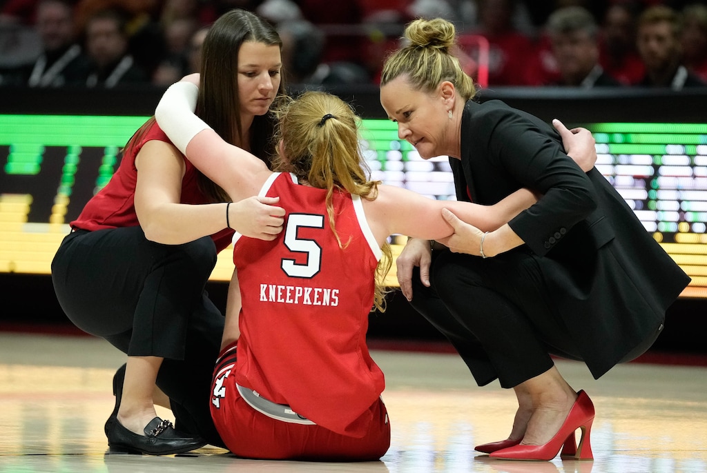 (Francisco Kjolseth | The Salt Lake Tribune) Utah Utes guard Gianna Kneepkens (5) injures her foot as she is helped off the court by athletic trainer Christina Jones, left, and head coach Lynne Roberts during the end of game play against BYU in NCAA basketball at the Huntsman Center in Salt Lake City on Saturday, Dec. 2, 2023.