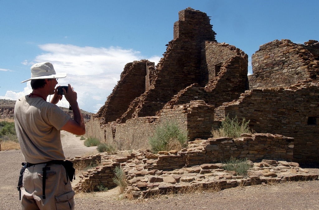 (Jeff Geissler | AP file photo) In this Aug. 10, 2005 file photo, tourist Chris Farthing from Suffolks County, England, takes a picture of Anasazi ruins in Chaco Culture National Historical Park in New Mexico. The preservation and protection of Native American cultural sites would be a priority of U.S. land managers under one of the options up for consideration as they work to amend an outdated guide for management of oil and gas drilling across a sprawling area of northwestern New Mexico.
