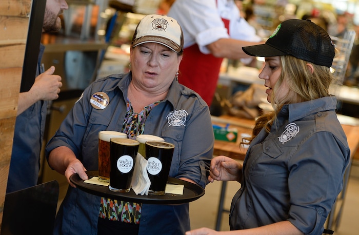 (Francisco Kjolseth  |  The Salt Lake Tribune)  Stacy Arnet, left, and Lexi Diamond serve up a round of pints for customers at the new Silver Mine Taproom located inside the new Whole Foods Market in Park City on Wednesday, Oct. 18, 2017. 