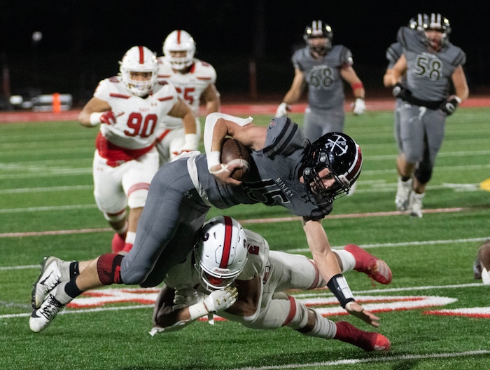 (Francisco Kjolseth | The Salt Lake Tribune) Blake Tabaracci (15) of Park City is upended by Amini Amone (2) of East High In prep football action in Park City on Friday, Sept. 3, 2021.