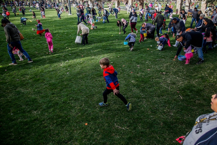(Nicole Boliaux | For The Tribune) Children and their families run to grab Easter eggs during the annual Easter egg hunt put on by A Kid's Place Dentistry in Liberty Park in Salt Lake City on Saturday, March 31, 2018.