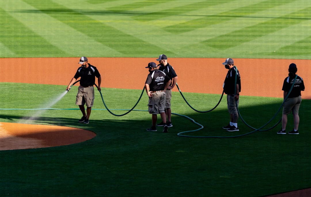 (Francisco Kjolseth | The Salt Lake Tribune) Ground crews prepare the field for the start of the Salt Lake Bees season home opener at Smith’s Ballpark Thursday night, May 6, 2021, after shutting down last season due to the pandemic.