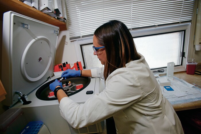 (Luis Sánchez Saturno | Santa Fe New Mexican | The Associated Press) In this Wednesday, April 25, 2018 photo, Tamara Flys, director of research at Southwest Care in Santa Fe, N.M., places a patient's blood sample in a centrifuge to prepare the blood to be sent out for testing. The HIV/AIDS clinic has been at the forefront of AIDS research over the past 30 years.