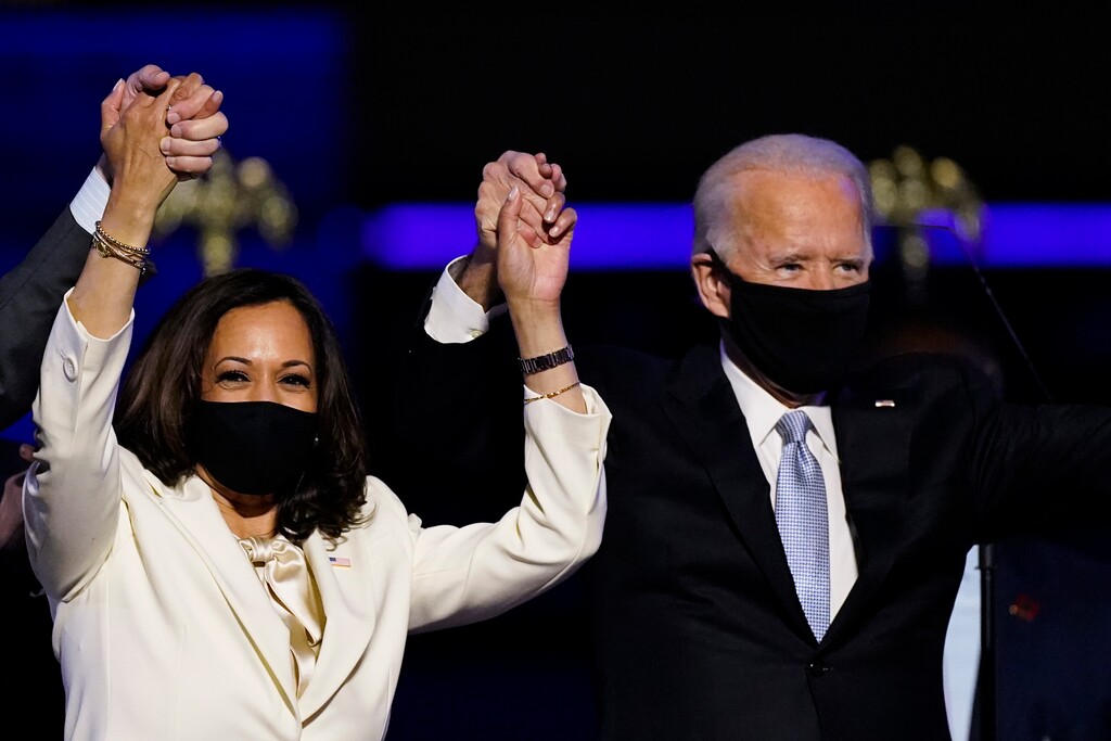 (Andrew Harnik | AP file photo) - In this Nov. 7, 2020, photo Vice President-elect Kamala Harris holds hands with President-elect Joe Biden and her husband Doug Emhoff as they celebrate in Wilmington, Del. On Thursday, President-elect Joe Biden narrowly won Arizona, capturing the state’s 11 electoral votes.