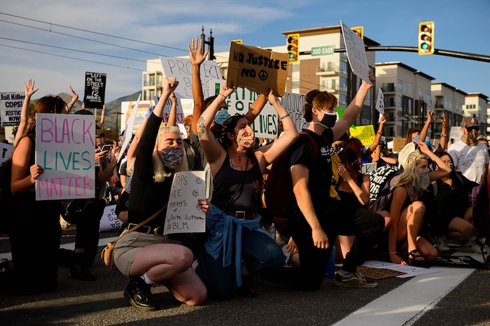 (Trent Nelson  |  The Salt Lake Tribune) Protesters kneel in front of police during a protest against police brutality in Salt Lake City on Monday, June 1, 2020.
