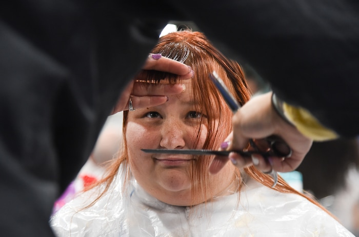 (Francisco Kjolseth  |  The Salt Lake Tribune)  Riley Hunter looks as Caitlyn Clarke cuts her bangs during Salt Lake CityÕs second annual Project Homeless Connect at the Salt Palace Convention Center on Friday, Oct. 12, 2018.