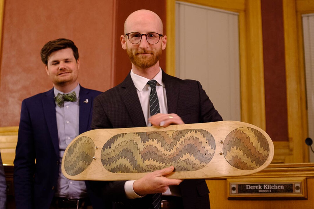 (Trent Nelson | The Salt Lake Tribune)  Outgoing Salt Lake City Council Member Derek Kitchen is given a piece of art, a skateboard by artist Evan Jed, at the council meeting on Tuesday Nov. 27, 2018. At rear is Council Member Chris Wharton.