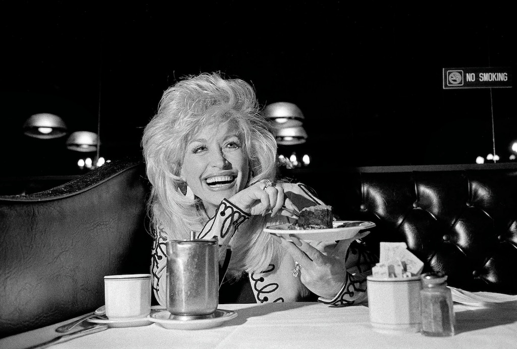 FILE Ñ Dolly Parton, savoring a chocolate mousse cake. Parton, the country singer, songwriter, entertainer and entrepreneur whose rags-to-riches story, outsize persona and prodigious vision and talent placed her in a class by herself, died in Nashville on Tuesday, Aug. 25, 2026. She was 80. (Edward Keating/The New York Times)