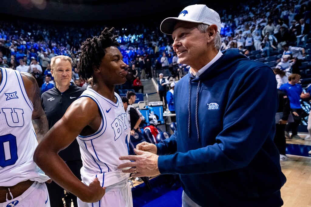 (Trent Nelson  |  The Salt Lake Tribune) BYU Cougars guard Robert Wright III (1) and BYU legend Danny Ainge celebrate a win last season.