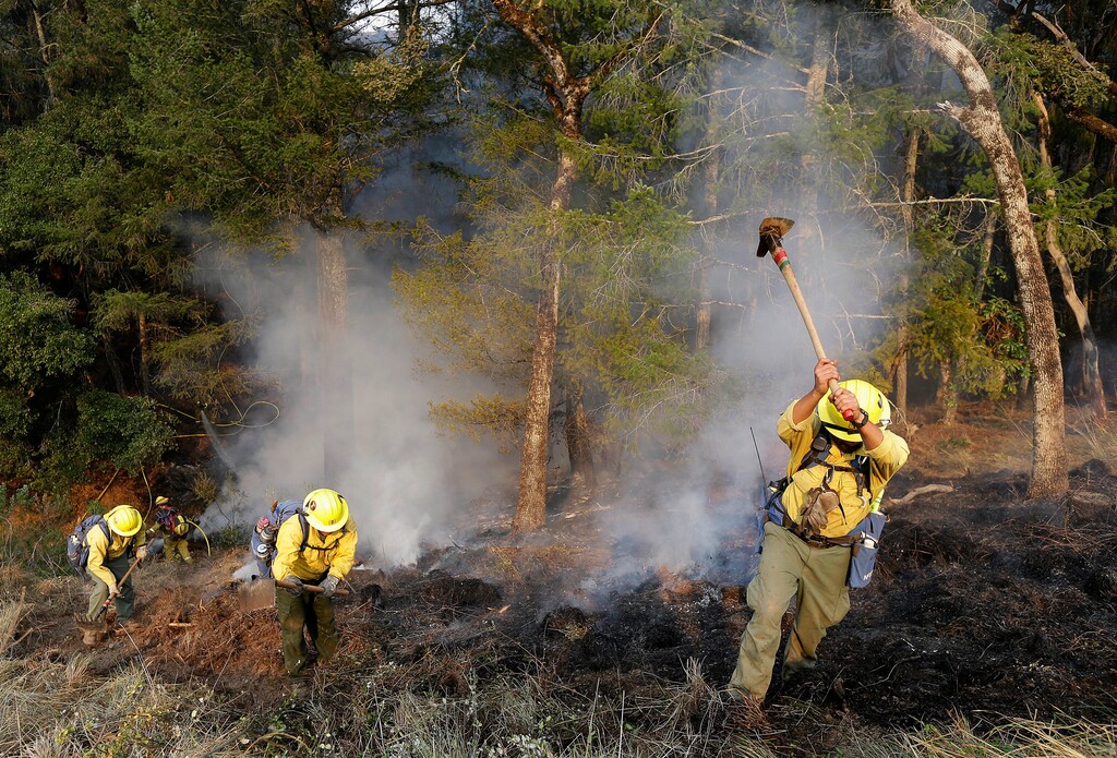 (AP Photo | Jeff Chiu) A hand crew works on hot spots on a hill in the Oakmont area of Santa Rosa, Calif., Thursday, Oct. 12, 2017. A forecast for gusty winds and dry air threatened to fan the fires, which are fast becoming the deadliest and most destructive in California history after destroying thousands of homes and businesses.