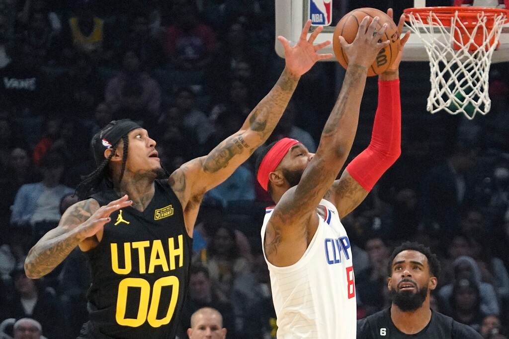 Los Angeles Clippers forward Marcus Morris Sr., center, shoots as Utah Jazz guard Jordan Clarkson defends during the first half of an NBA basketball game Sunday, Nov. 6, 2022, in Los Angeles. (AP Photo/Mark J. Terrill)