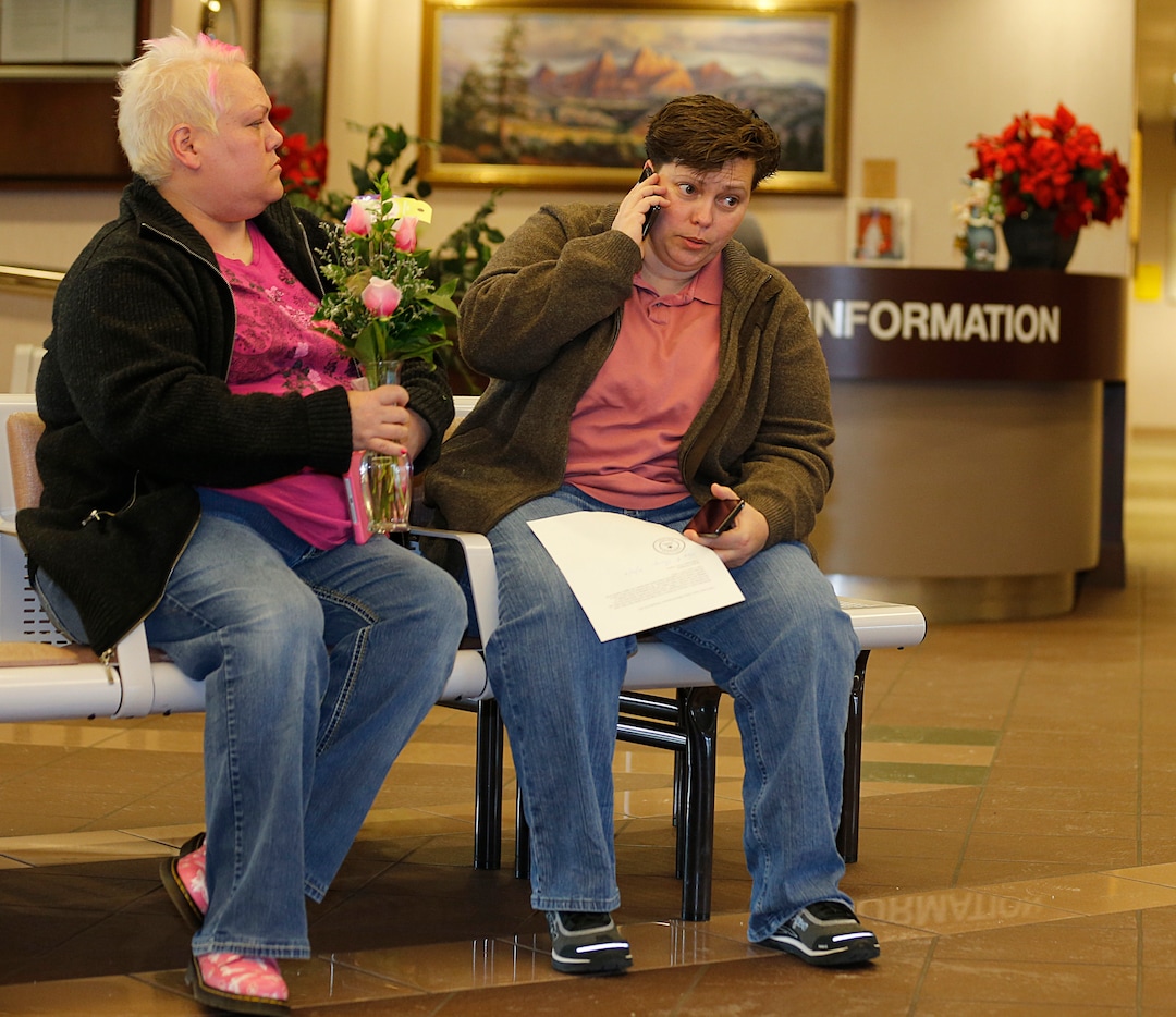 Patsy Carter left, and Raylynn Marvel  right, from Orem, Utah, talk on the phone outside the offices of the Utah County Clerk and Auditor office and hold a rejection letter for a marriage license on July 20, 2013 in Provo, Utah. A Federal Judge on Friday struck down Utah's ban on same sex marriage saying the law violates the U.S. Constitution.  (Photo by George Frey  |  Special to the Tribune)