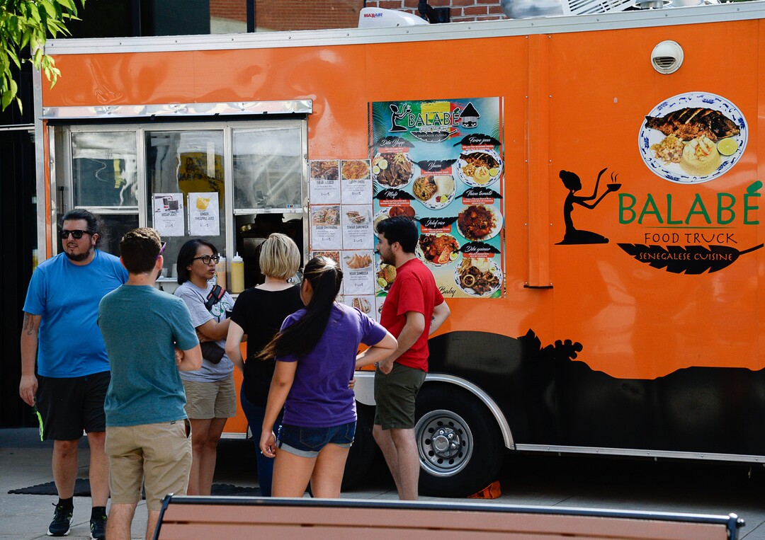 (Francisco Kjolseth  |  The Salt Lake Tribune)  People gather around the Balabe Senegalese food truck during Trolley Square Food Truck Night on Wednesday, July 17, 2019. Three of the vendors for the night, along with four others, will vie for the title of Best New Food Truck on Aug. 3 at the Food Truck and Brewery Battle at The Gateway.