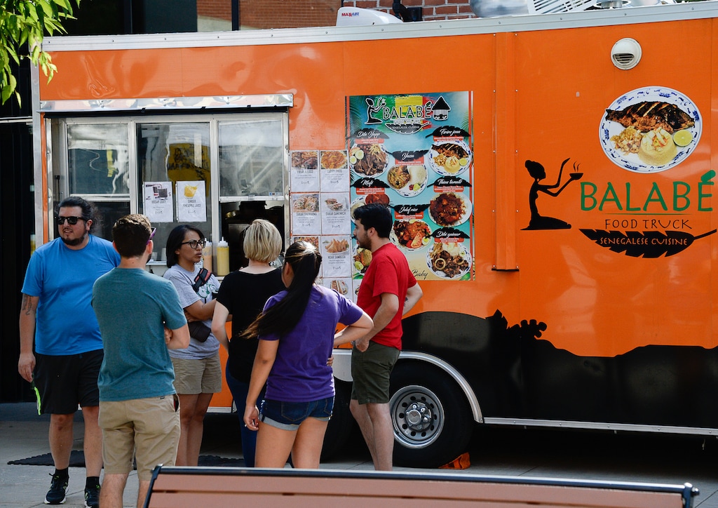 (Francisco Kjolseth | The Salt Lake Tribune) People gather around the Balabe Senegalese food truck during Trolley Square Food Truck Night on Wed. July 17, 2019. It will vie for the title of Best New Food Truck on Aug. 3 at the Food Truck and Brewery Battle at The Gateway.