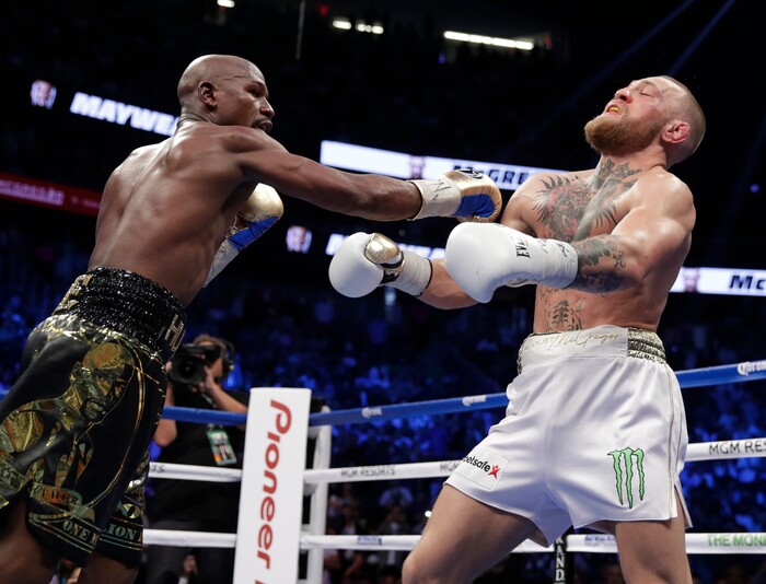 Floyd Mayweather Jr. hits Conor McGregor in a super welterweight boxing match Saturday, Aug. 26, 2017, in Las Vegas. (AP Photo/Isaac Brekken)
