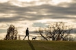 (Rick Egan | The Salt Lake Tribune) A man walks his dog at Liberty Park in Salt Lake City on Tuesday, Dec. 9, 2025. Unseasonably warm temperatures have hit along the Wasatch Front this week, as much as 20 degrees above historic normal.