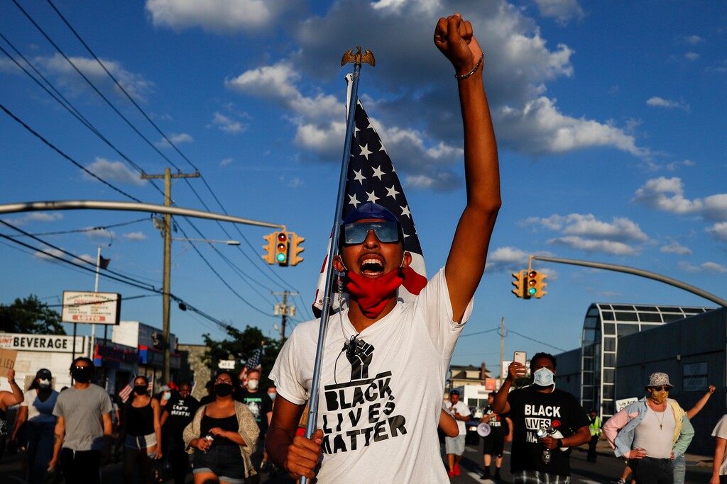 A protester leads a chant down a main thoroughfare during a Black Lives Matter march through a residential neighborhood calling for racial justice, Monday, July 13, 2020, in Valley Stream, N.Y. (AP Photo/John Minchillo)