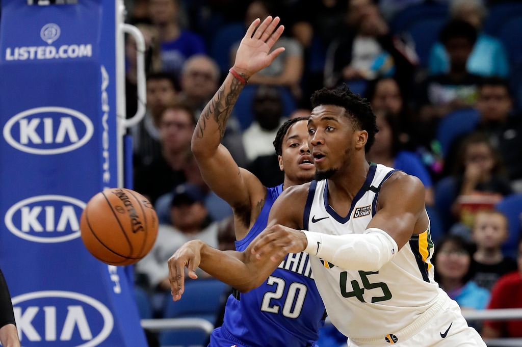 Utah Jazz guard Donovan Mitchell (45) passes the ball past Orlando Magic guard Markelle Fultz (20) during the first half of an NBA basketball game, Saturday, Jan. 4, 2020, in Orlando, Fla. (AP Photo/John Raoux)