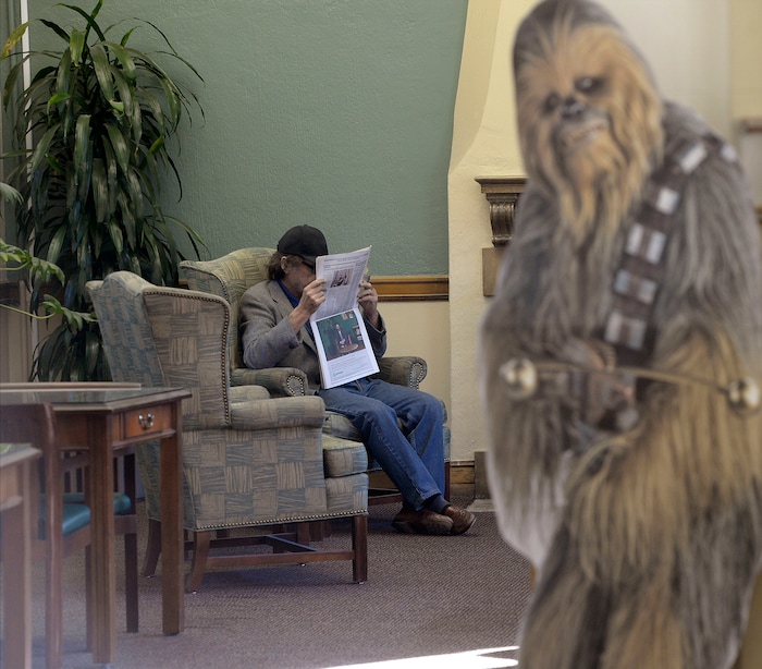 (Al Hartmann | The Salt Lake Tribune)
Patron reads newspaper in Sprague Library's comfortable reading room Monday Oct. 23. It's open with limited service after its basement flooded in July, causing a loss of thousands of books. The main floor of the English Tudor style building is open and rearranged. The basement which housed non-fiction, children's books, and community meeting rooms will remain closed for some time.