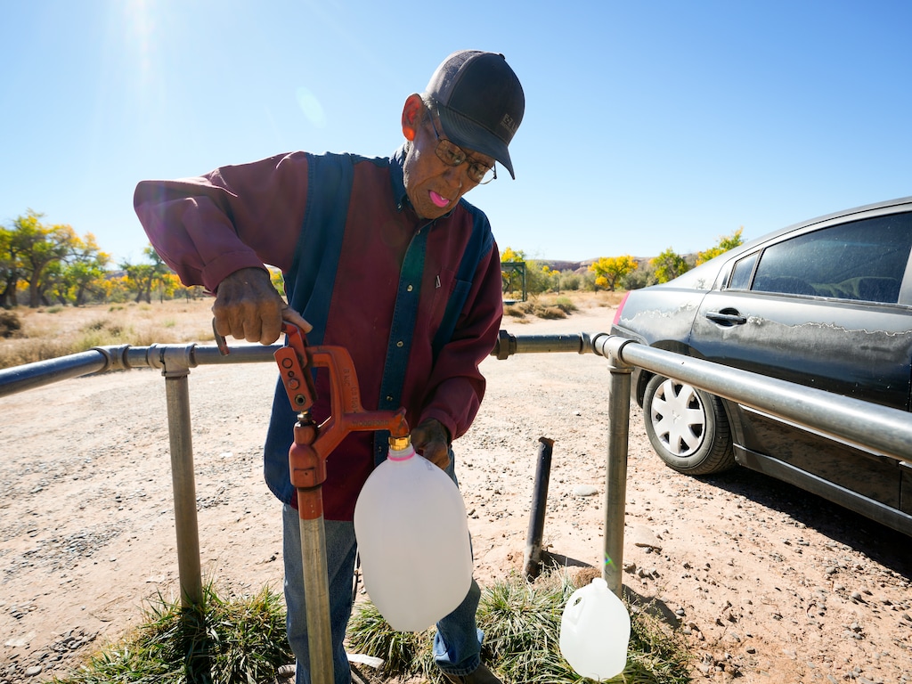 (Bethany Baker | The Salt Lake Tribune) Norman Sam fills up a jug of water from the water spigot available for public use after travelling 30 miles to the same well that his grandparents used at St. Christopher's Mission Episcopal Church in Bluff on Thursday, Oct. 19, 2023.