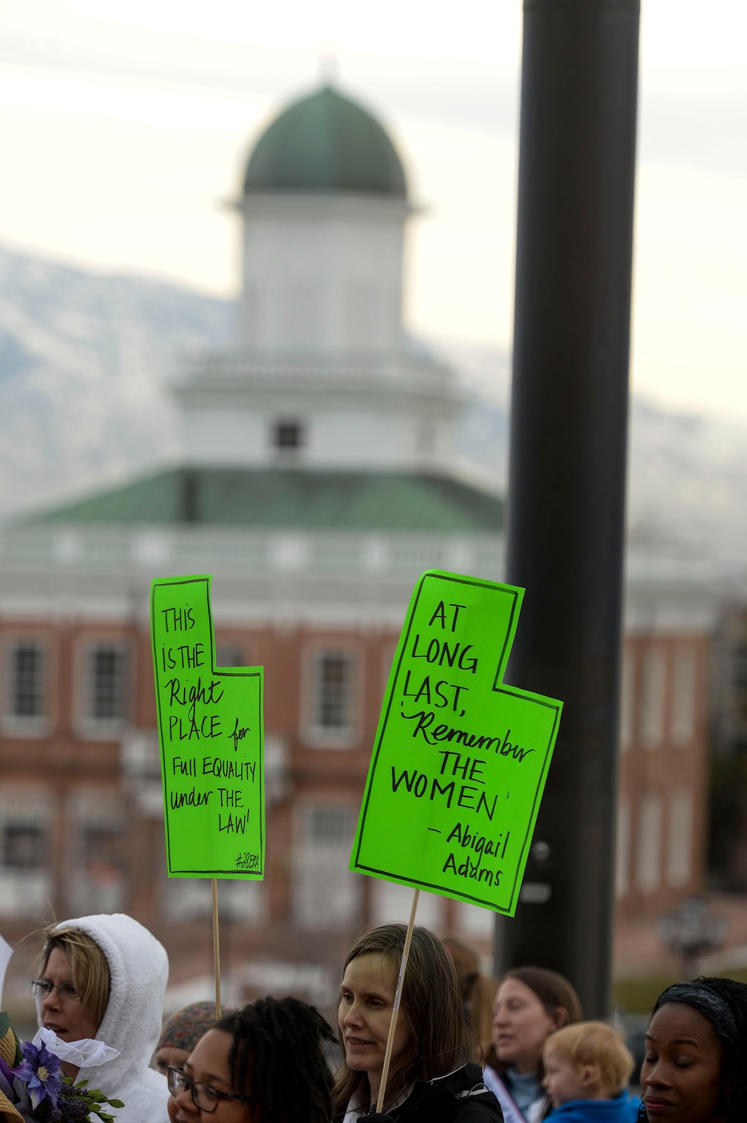 (Leah Hogsten  |  The Salt Lake Tribune) Signs celebrate equal rights and Seraph Young who cast her vote in the Council Hall building across from the Capitol.  League of Women Voters of Salt Lake and Utah rally on Friday, Feb. 14, 2020 in celebration of 150 years since Utah women voted, 100 years of the 19th Amendment and the 100th anniversary of League of Women Voters.