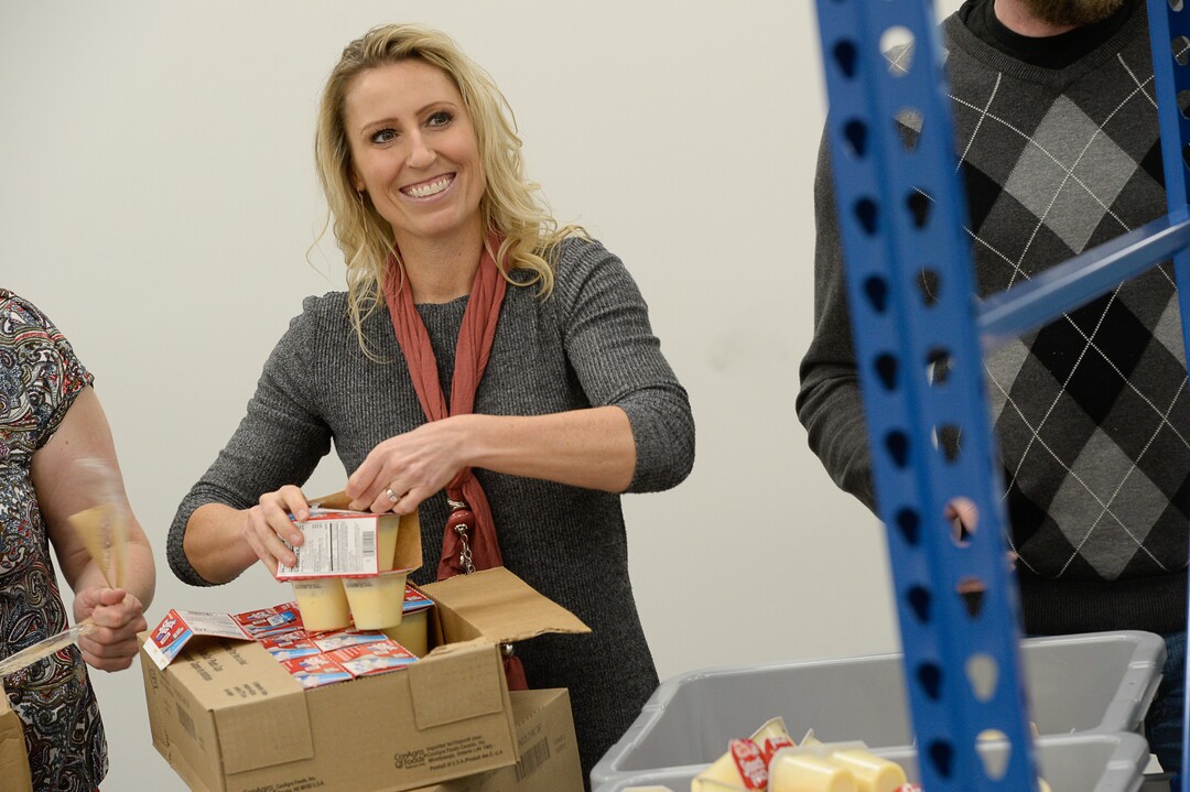 (Francisco Kjolseth  |  The Salt Lake Tribune)  Michelle Benedict, who founded Kids Next Door and is now the engagement manager for USANA Kids Eat, pitches in restocking the line as USANA staff volunteer their time assembling food bags for at-risk youth at the newly-renovated packing and storage facility next to the headquarters of the Salt Lake City company on Wed. Dec. 11, 2019. The USANA Foundation has acquired two local charities, Kids Next Door and KidsEat!, that provides hundreds of food bags every week for the kids for the weekends and during long school breaks.