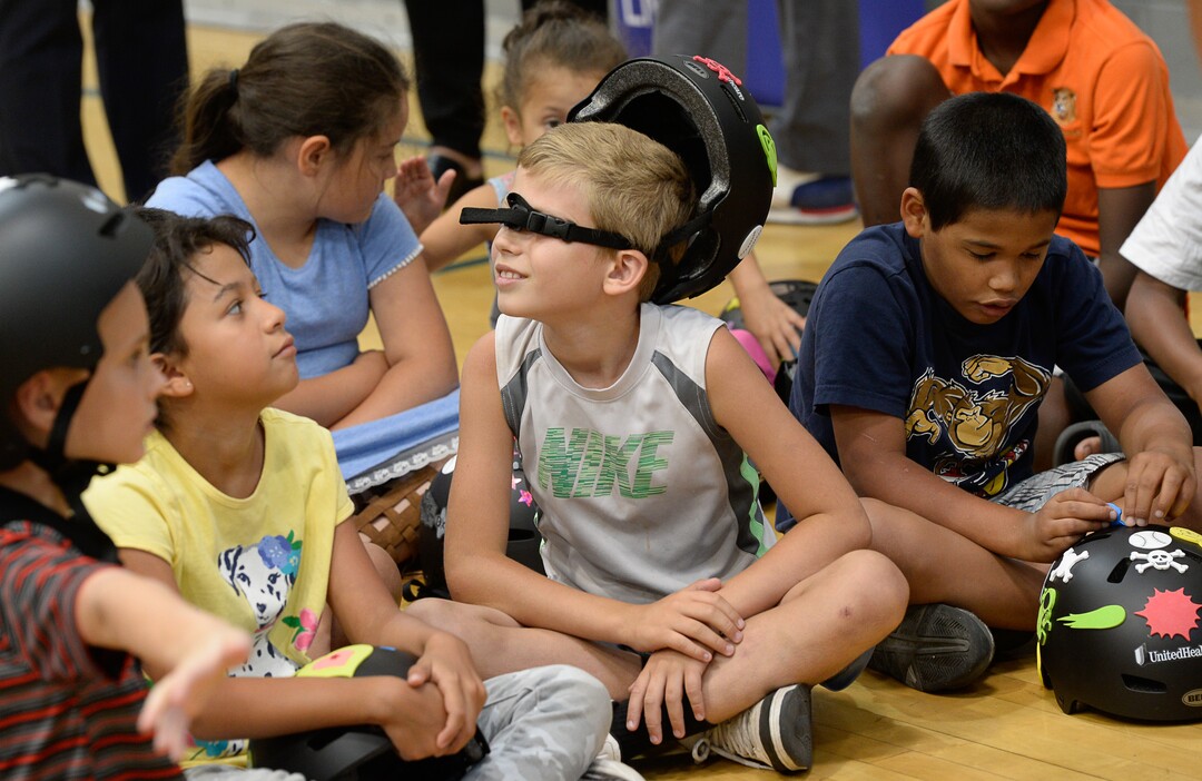 (Francisco Kjolseth  |  The Salt Lake Tribune)  In advance to the upcoming Tour of Utah bicycle race, more than 50 Salt Lake City-area kids receive a new bicycle helmet at the Capitol West Boys & Girls Club on Tuesday, July 31, 2018, as kids play around with their new bicycle accessory. As part of UnitedHealthcare's Pro Cycling team and community outreach program to keep kids healthy and active, team cyclists Jonny Clarke and Sebastian Haedo engage the kids in a few warm up routines before getting on the bike.
