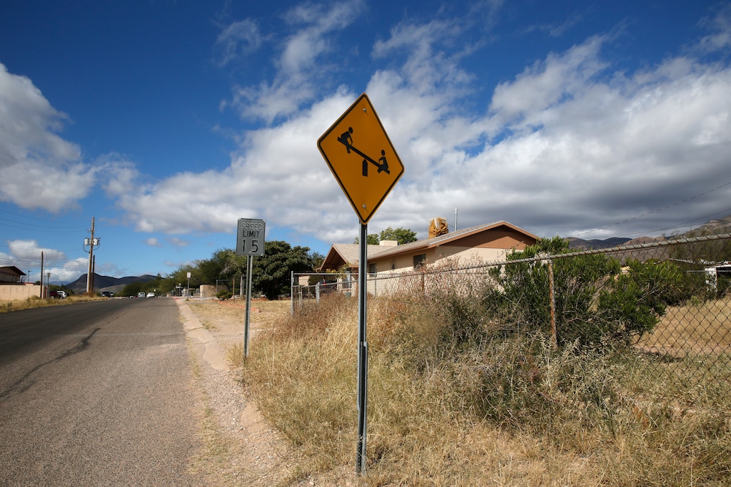 (Dario Lopez-Mills | AP) A “playground ahead” warning stands by the side of a road on the outskirts of Bisbee, Ariz., Oct. 26, 2021. Bisbee was home to Paul and Leizza Adams, and their six children, before Paul and Leizza were charged with child sexual abuse.