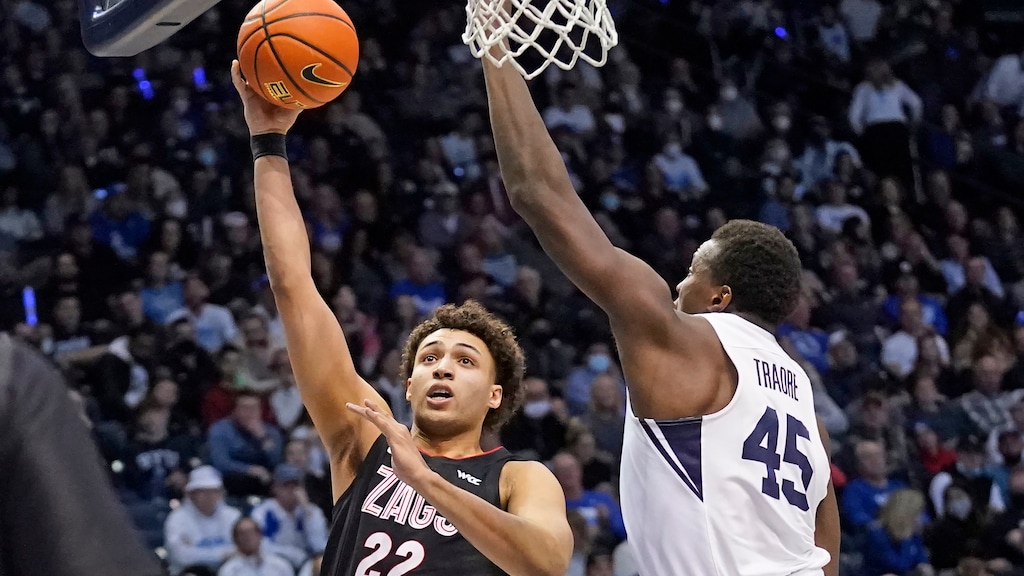 Gonzaga forward Anton Watson (22) goes to the basket as BYU forward Fousseyni Traore (45) defends during the first half of an NCAA college basketball game Saturday, Feb. 5, 2022, in Provo, Utah. (AP Photo/Rick Bowmer)