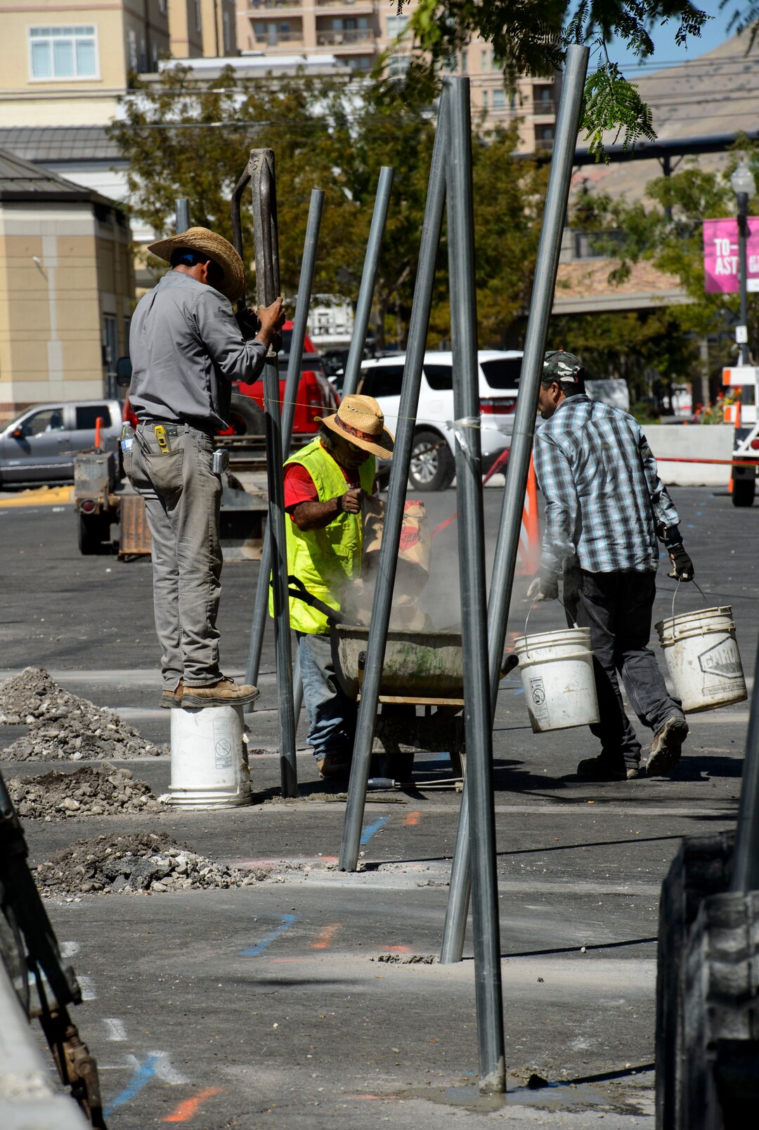 (Steve Griffin  |  The Salt Lake Tribune) Workers cement  fence posts into position on Rio Grande Street in Salt Lake City Monday September 11, 2017.