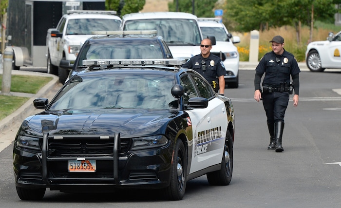 (Francisco Kjolseth  |  The Salt Lake Tribune)  Police gather at the scene where activists staged a protest against a private prison company with contracts to hold undocumented immigrants on Thursday, July 12, 2018, at the headquarters of Management and Training Corporation in Centerville.
