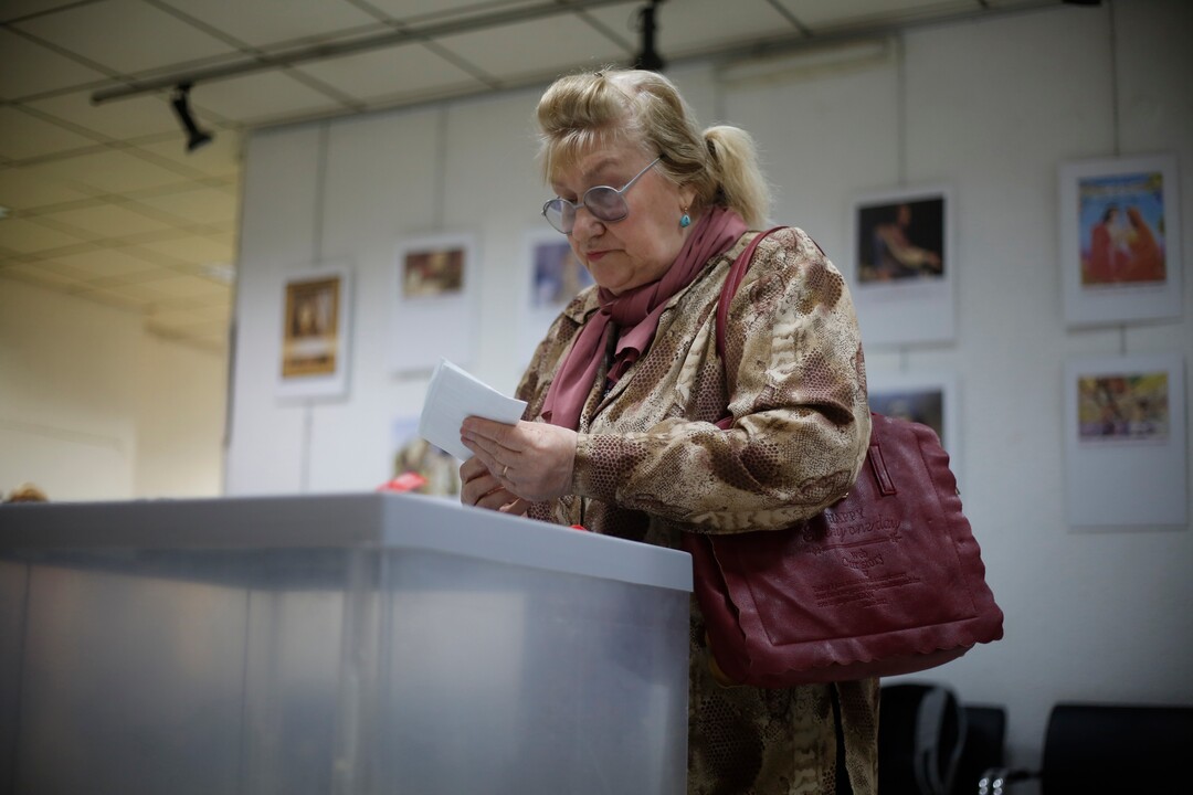 A Russian woman is abut to cast her ballot for the presidential election in Netanya, Israel, Sunday, March 18, 2018. Russians in Israel are voting in a presidential election in which Vladimir Putin is seeking a fourth term in the Kremlin. (AP Photo/Ariel Schalit)