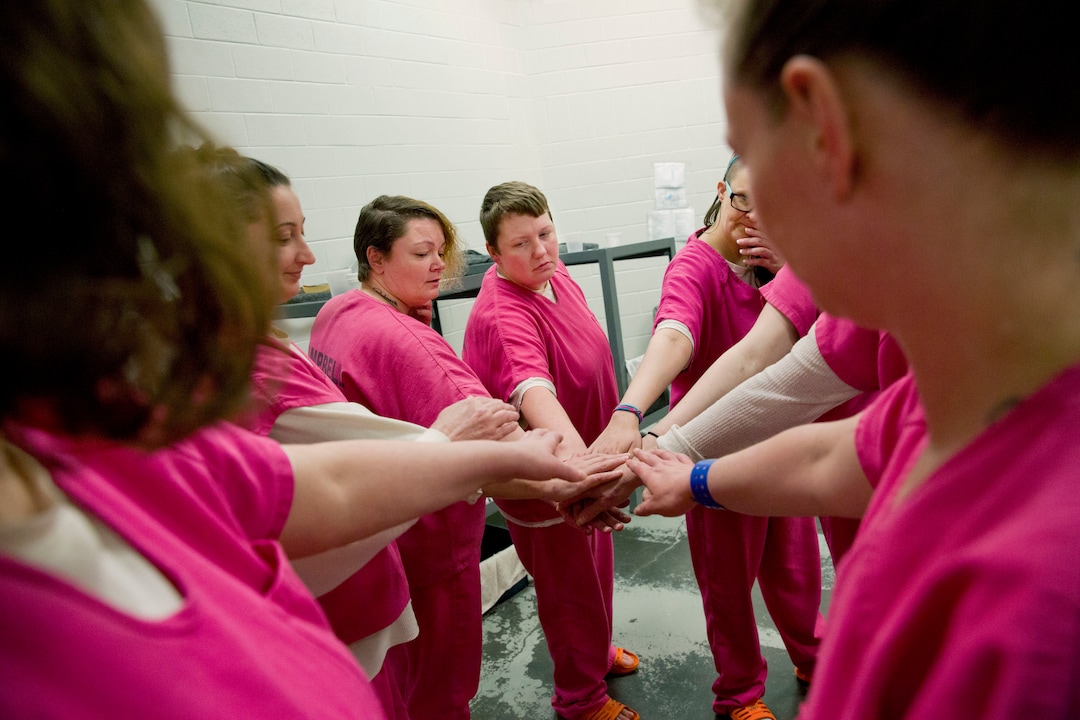 From left, cellmates Elsie Kniffen, 39, Mary Sammons, 41, Blanche Ball, 30 and Sarai Keelean, 35, join hands after a prayer in the Campbell County Jail in Jacksboro, Tenn., Tuesday, March 20, 2018. Many of the women say jail should help prepare them for life outside, maybe with a Narcotics Anonymous group, counseling or education programs such as those offered in state prisons. Lt. Mallory Campbell, assistant jail administrator says she'd like to offer college courses or vocational training because "if they don't leave here with a skill, they're going to go back to what they know." But there isn't money for programs or staff. (AP Photo/David Goldman)