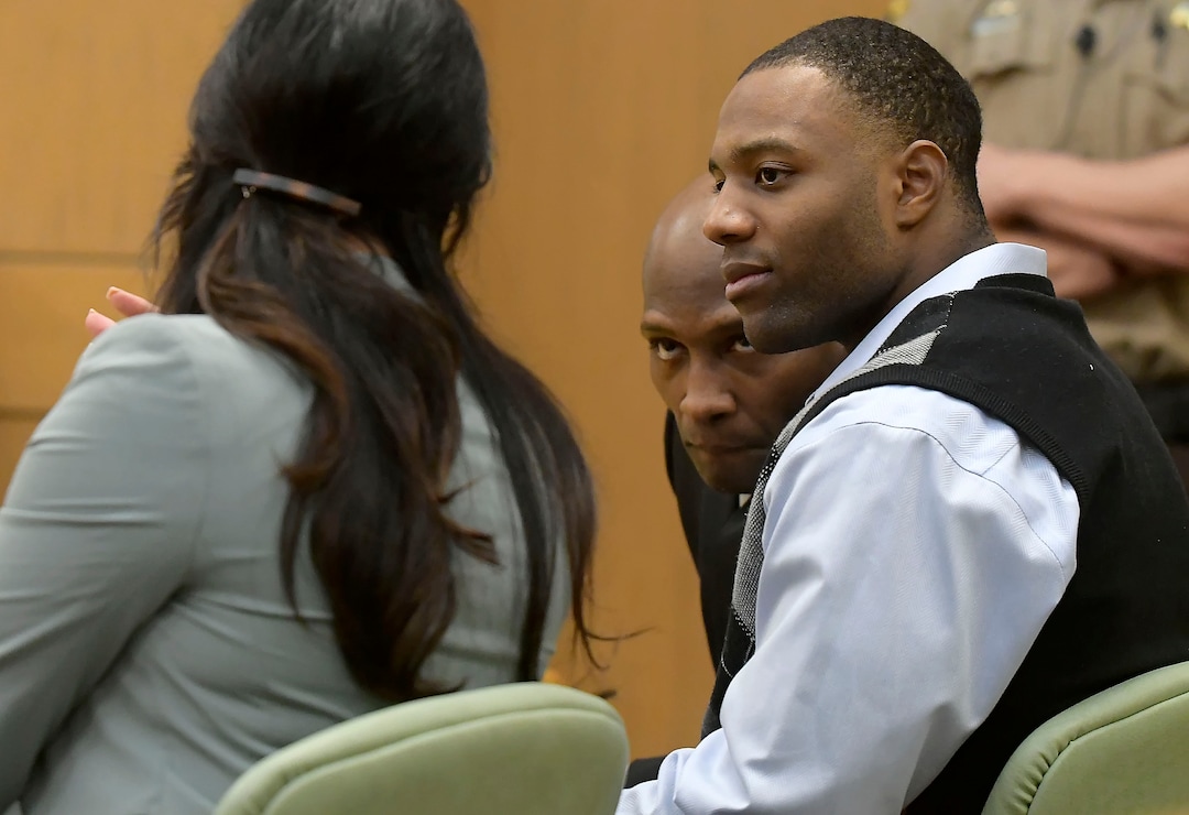 Torrey Green talks with his lawyer Skye Lazaro, left, and private investigator E. Christian Warmsley during his rape trial, Wednesday, Jan.16, 2019 in Brigham City, Utah. Green is accused of raping multiple women while he was a football player at Utah State University. (Eli Lucero/Herald Journal via AP)