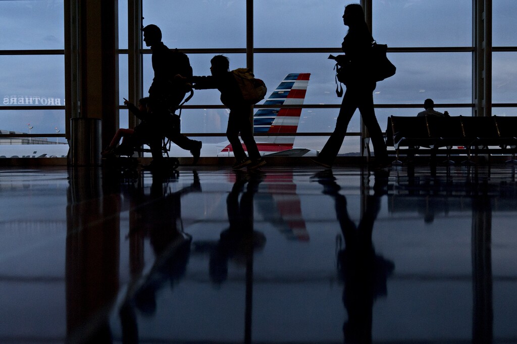 (Andrew Harrer | Bloomberg) Travelers walk through Ronald Reagan National Airport (DCA) in Washington, D.C.