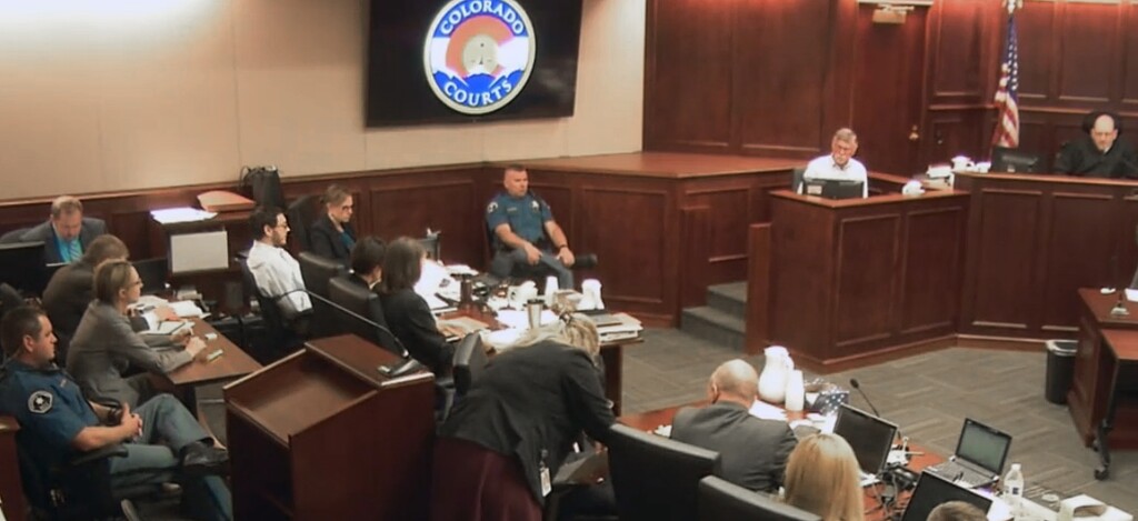 In this image made from Colorado Judicial Department video, Robert Holmes, top second from right, the father of James Holmes, fifth from left in white shirt, gives testimony during the sentencing phase of the Colorado theater shooting trial in Centennial, Colo., on Wednesday, July 29, 2015. Judge Carlos A. Samour Jr. is seen at top right. (Colorado Judicial Department via AP, Pool)