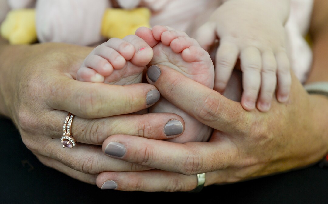 (Leah Hogsten  |  The Salt Lake Tribune) Ramsi Stoker cradles the feet of her daughter Riarson, 7 months, at their home on Friday, Aug. 2, 2019. Stoker's two oldest children were conceived through in vitro fertilization. The two youngest were conceived naturally. Ramsi Stoker, 39, and her husband, Brian, not pictured, struggled with unexplained infertility until seeking help from the Utah Fertility Center and the Footsteps to Fertility program in 2012.