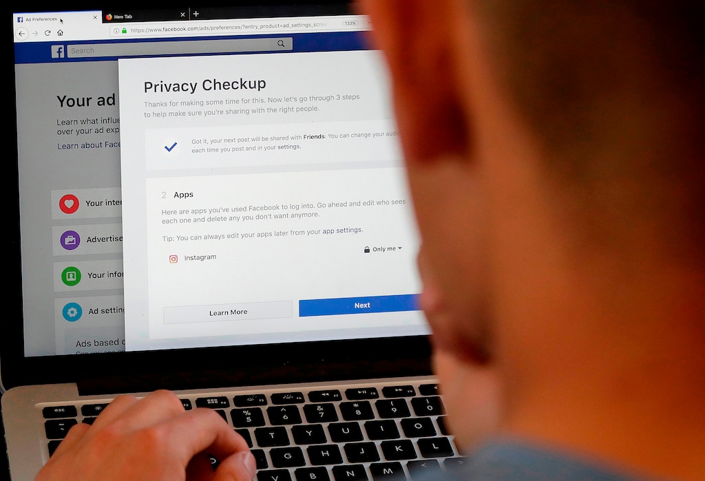 FILE - In this March 26, 2018, file photo, a man poses for photos in front of a computer showing Facebook ad preferences pages in San Francisco. If you’ve made changes to how you use social media since Facebook’s Cambridge Analytica privacy debacle, you’re not alone. A new poll by the Associated Press-NORC Center for Public Affairs Research found that 7 out of 10 of online adults who’ve heard of the Cambridge Analytica scandal have changed their behavior on social media. (AP Photo/Jeff Chiu, File)