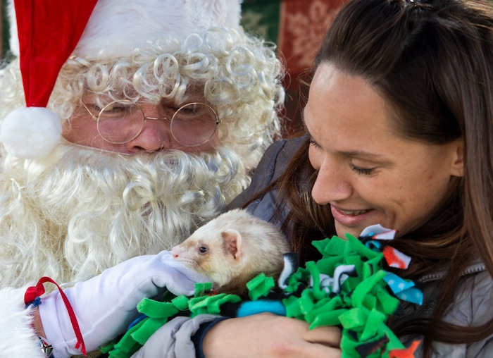 (Rick Egan  |  The Salt Lake Tribune)   Natalie Weinstein sits on Santa's lap with her pet ferret Kdoh visit Santa Claus during the Street Dawg Crew Christmas outreach at Liberty Park Sunday.  The Street Dawg Crew supports the homeless and their pets every Sunday at Pioneer Park. Today besides passing out food and gift bags for humans and animals, they offered a photo opportunity with Santa. Sunday, Dec. 22, 2019.