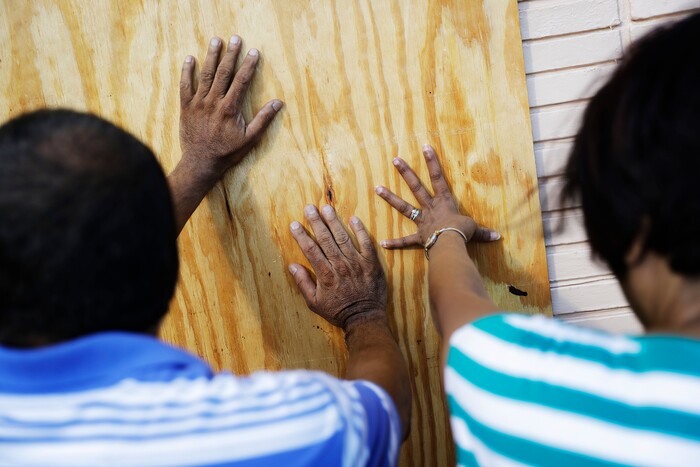 Richard Jay, left, and his wife Shanta board up their motel ahead of Hurricane Irma in Daytona Beach, Fla., Friday, Sept. 8, 2017. Coastal residents around South Florida have been ordered to evacuate as the killer storm closes in on the peninsula for what could be a catastrophic blow this weekend. (AP Photo/David Goldman)