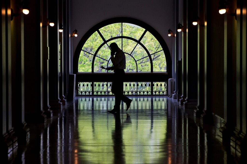 (Jacquelyn Martin | The Associated Press) In this April 30, 2015, file photo, a Capitol Hill staffer looks down at papers while on a cell phone while walking inside the Russell Senate Office Building on Capitol Hill in Washington. The Department of Homeland Security acknowledges detecting suspected cell tower simulators in Washington, D.C. These devices can track specific cell phones and even intercept or divert calls and text messages.
