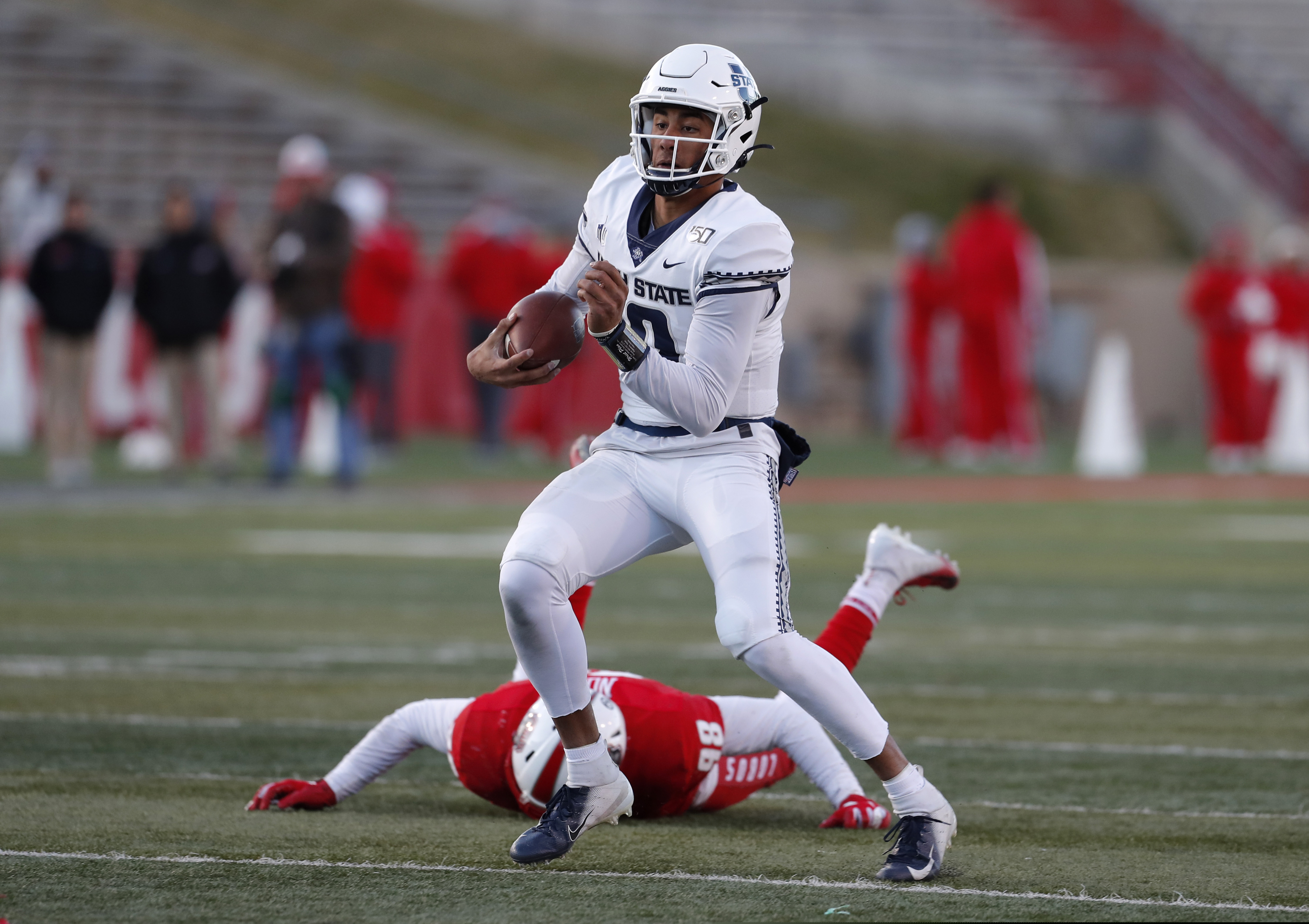 Utah State quarterback Jordan Love (10) runs for yardage after avoiding the tackle by New Mexico defensive lineman Joey Noble (98) during the second half of an NCAA college football game on Saturday, Nov. 30, 2019 in Albuquerque, N.M. (AP Photo/Andres Leighton)