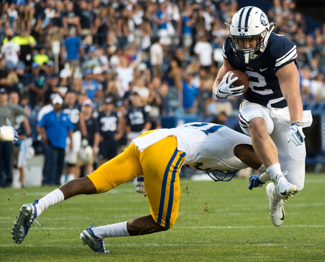 (Rick Egan  |  The Salt Lake Tribune)    Brigham Young Cougars running back Matt Hadley (2) runs the ball as McNeese State Cowboys defensive back Andre Sam (21) defends, in football action Brigham Young Cougars vs McNeese State Cowboys at Lavell Edwards Stadium, Saturday, Sept. 22, 2018.