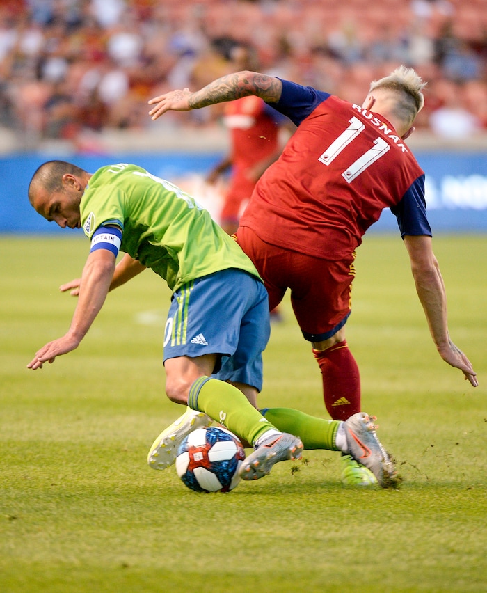 (Leah Hogsten  |  The Salt Lake Tribune) Seattle Sounders midfielder Nicolas Lodeiro (10) hits the pitch battling Real Salt Lake midfielder Albert Rusnak (11) as Real Salt Lake hosts the Seattle Sounders, Aug. 14, 2019, at Rio Tinto Stadium in Sandy.