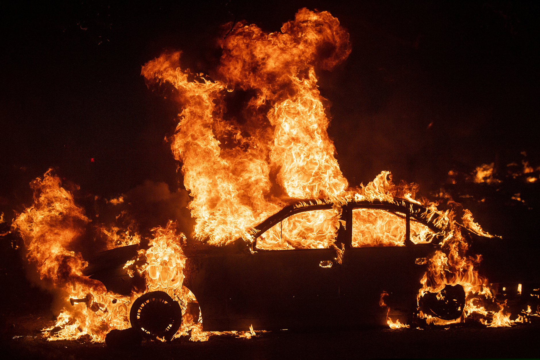 (Noah Berger | AP file photo)  Flames from the Kincade Fire consume a car in the Jimtown community of unincorporated Sonoma County, Calif., Oct. 24, 2019.