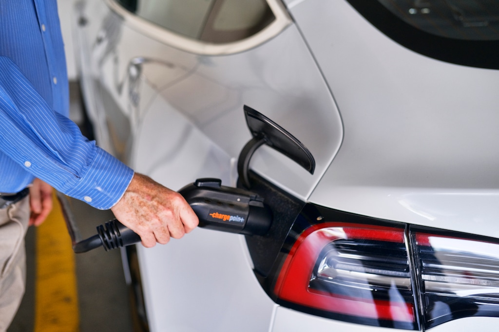 (Richard Vogel | AP file photo)
In this Oct. 16. 2019, photo, a driver plugs in the Charge Point electric plug into his Tesla car at a parking garage in downtown Los Angeles. Experts expect most new cars sold in 2030 to be electric. The Biden administration promised 550,000 charging stations to help with the transition to electric cars.
